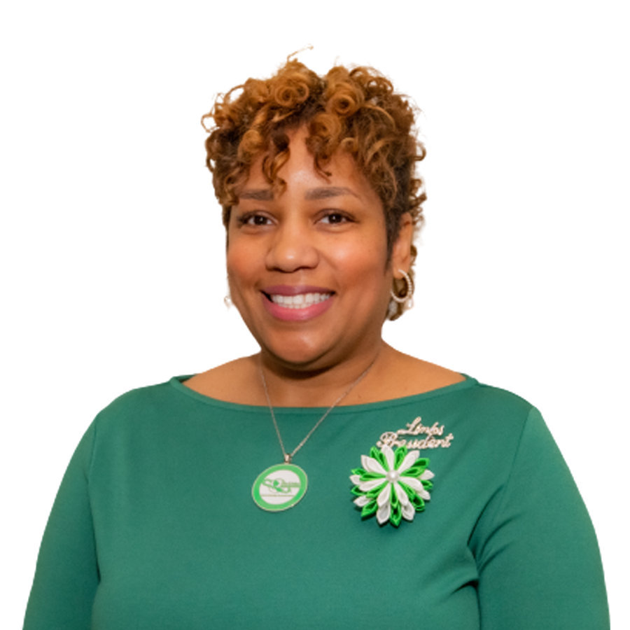 Woman with curly hair in a green dress, wearing a 