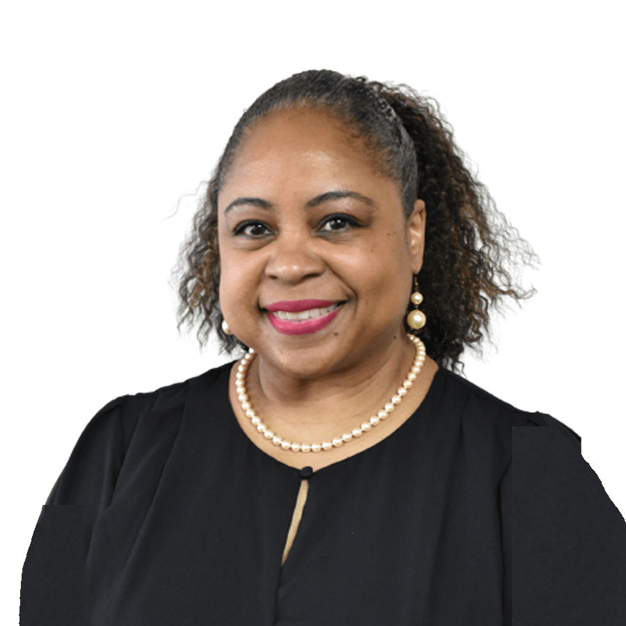 Woman smiling, wearing pearls and a black top, with a high ponytail, against a white background.