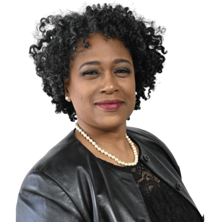 Woman with curly dark hair, wearing a black jacket and pearl necklace, smiling.