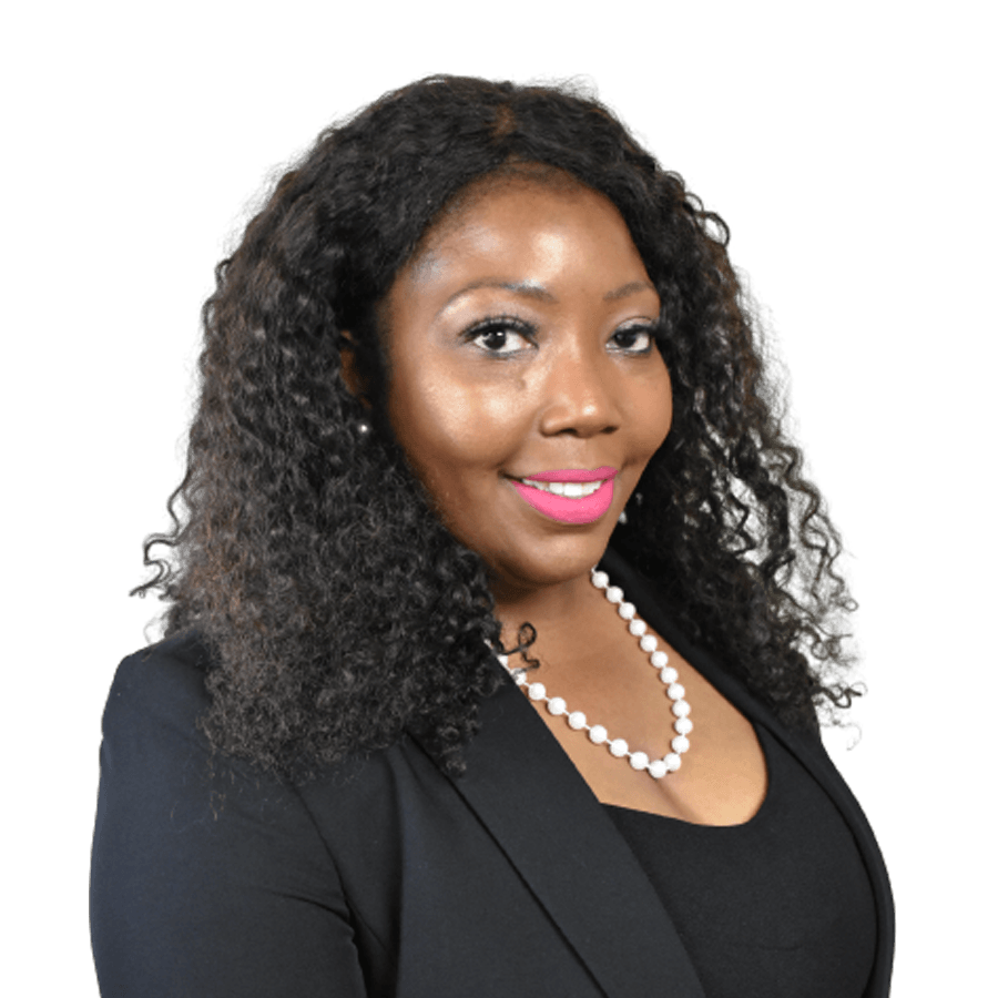 Woman wearing a black blazer and pearl necklace, smiling with pink lipstick.