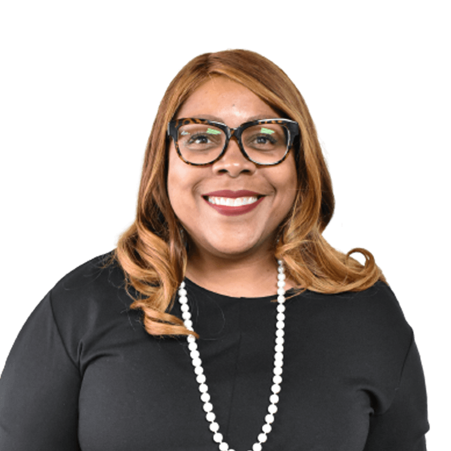 Woman with glasses and a pearl necklace smiling.