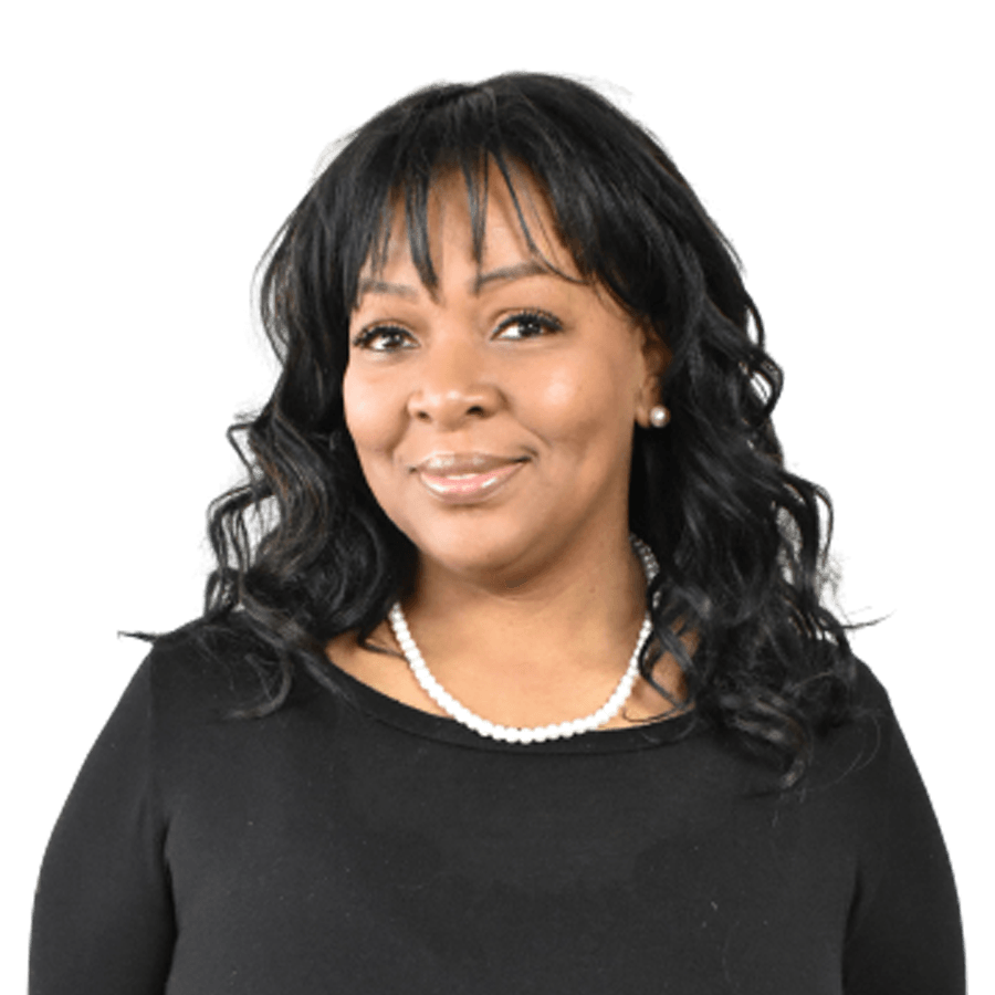 Woman with black hair, wearing a pearl necklace, smiling, and dressed in a black top.