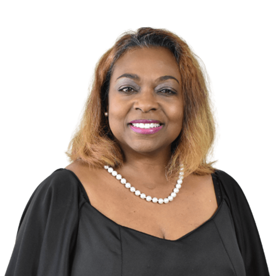 Woman with brown hair and pearl necklace, smiling, wearing black top, against a white background.