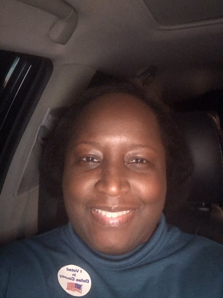 Smiling person wearing a blue shirt inside a car; a 