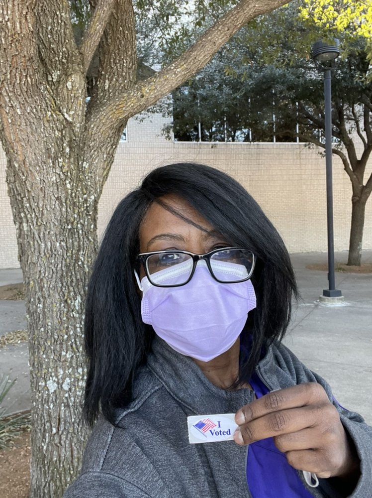 Person wearing a mask and glasses holds 