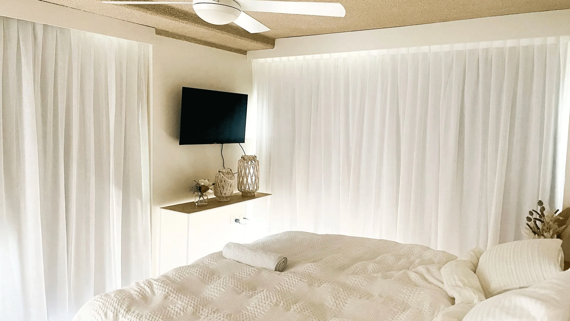 Bedroom With A Bed, Television, Ceiling Fan And White Curtains — Creative Curtains & Blinds In Tweed Heads South, NSW