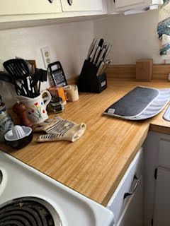Kitchen countertop with cooking utensils, knives, and oven.