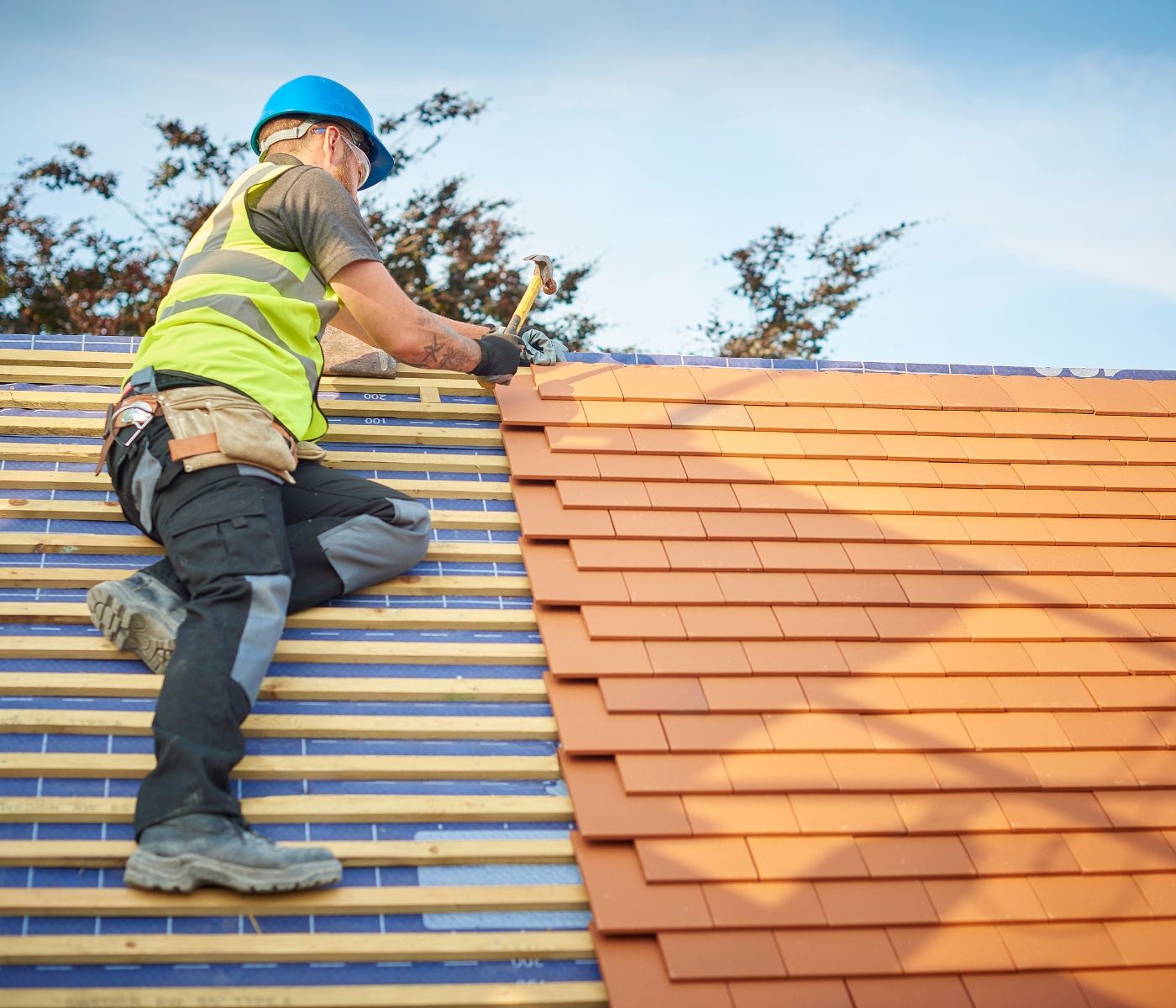 A man is working on the roof of a house.