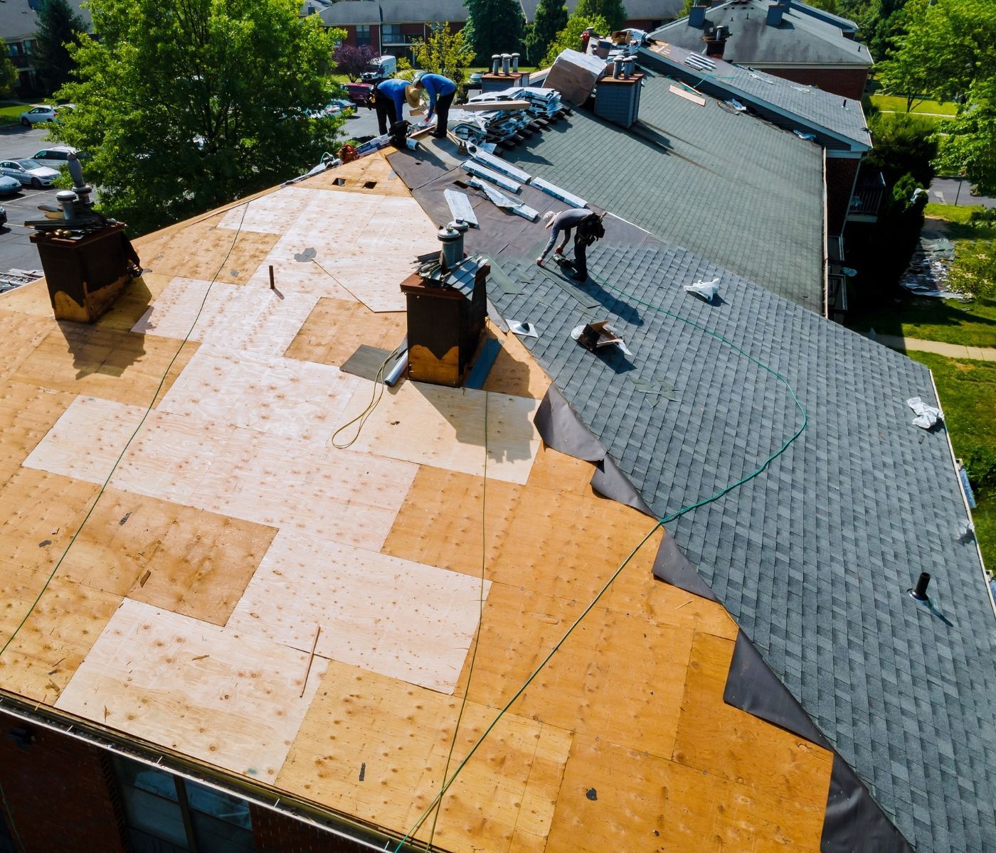 A group of people are working on the roof of a house.