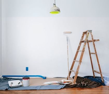 A wooden ladder is sitting on the floor in an empty room.