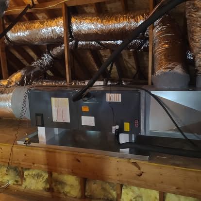 HVAC unit in an attic, with insulated ductwork.