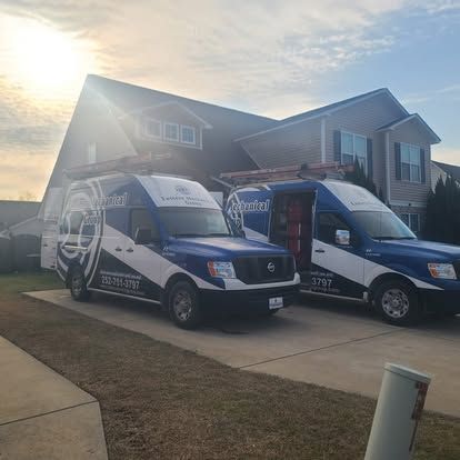 Two blue and white Gabriel service vans parked in front of a house on a sunny day.