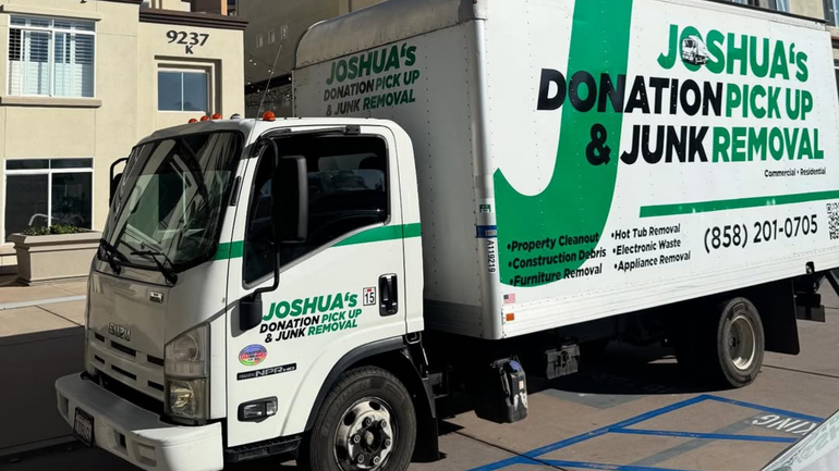 Joshua&rsquo;s Donation Pick Up & Junk Removal truck parked outside a building