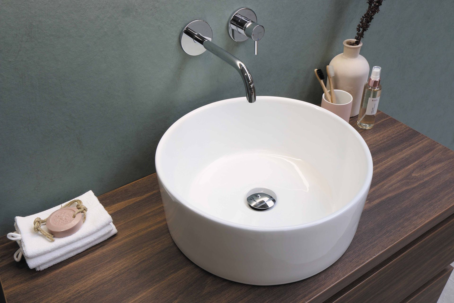 White circular ceramic sink with a sleek stainless steel faucet.