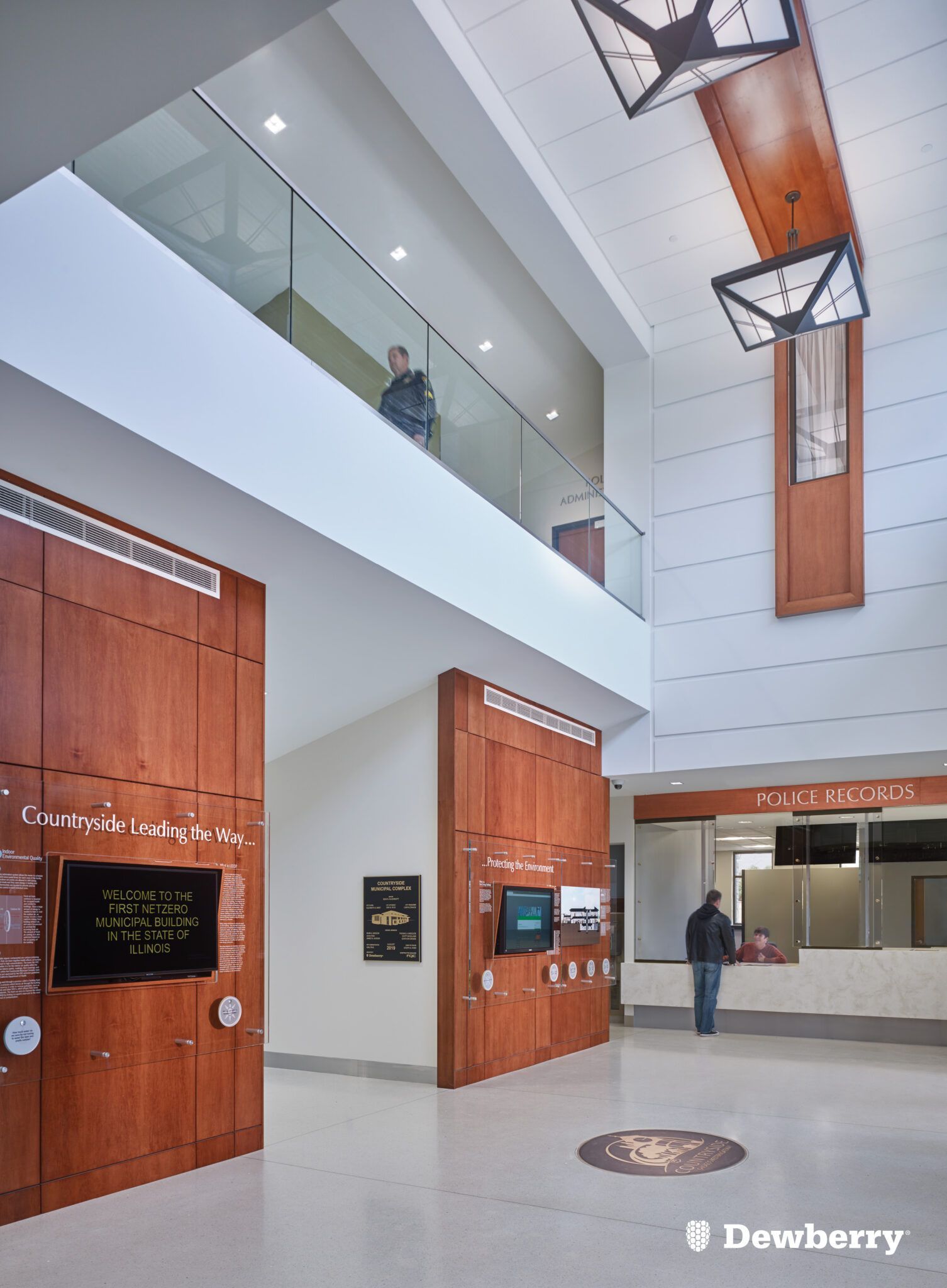 A man is standing in the lobby of a building looking up at the ceiling.