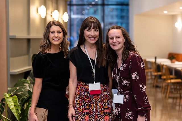 Three women are posing for a picture together in a room.