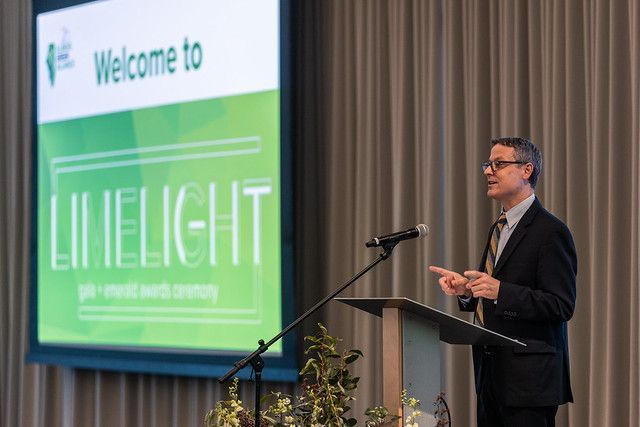A man in a suit is standing at a podium giving a speech.