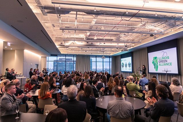 A large group of people are sitting at tables in a large room.