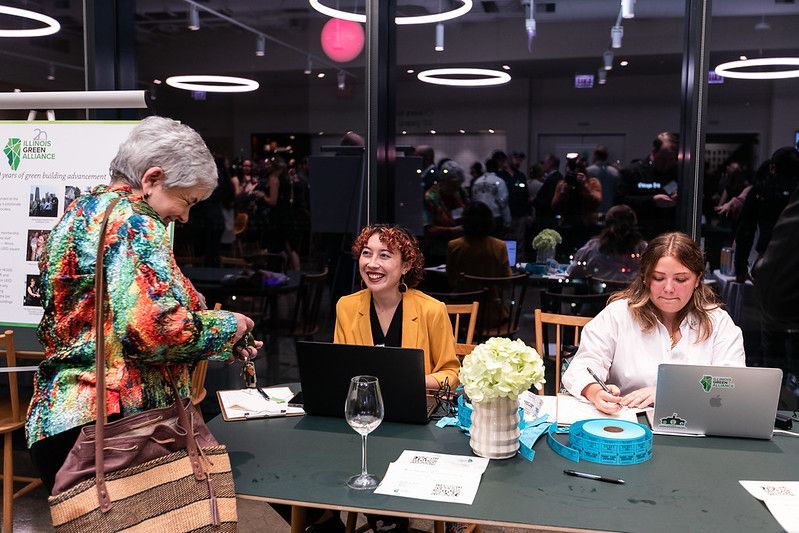 A group of women are sitting at a table with laptops.