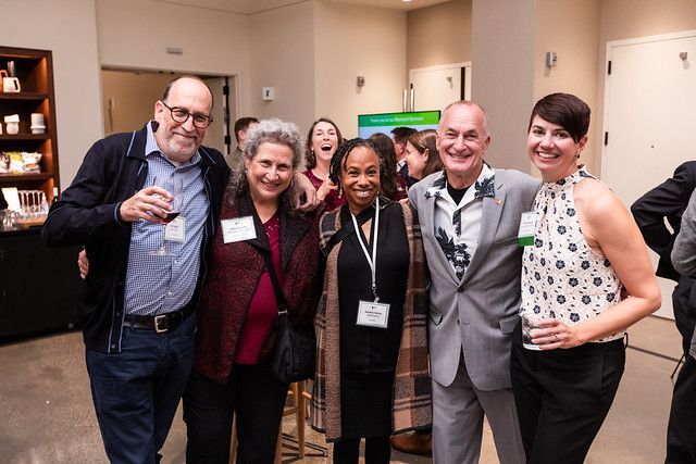 A group of people are posing for a picture in a room.