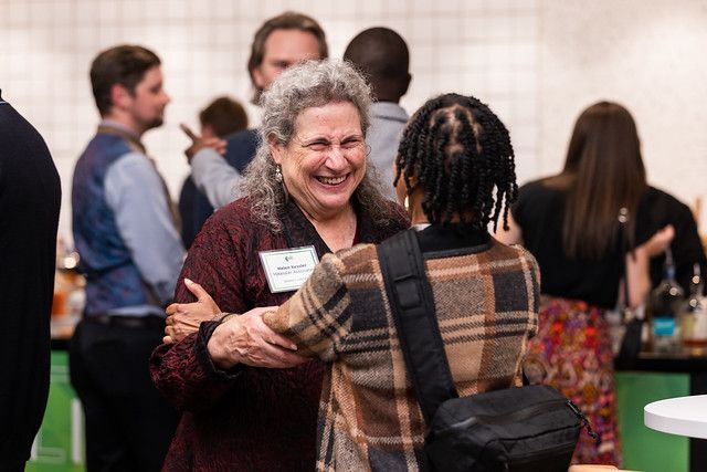 A woman is hugging another woman in a crowd of people.