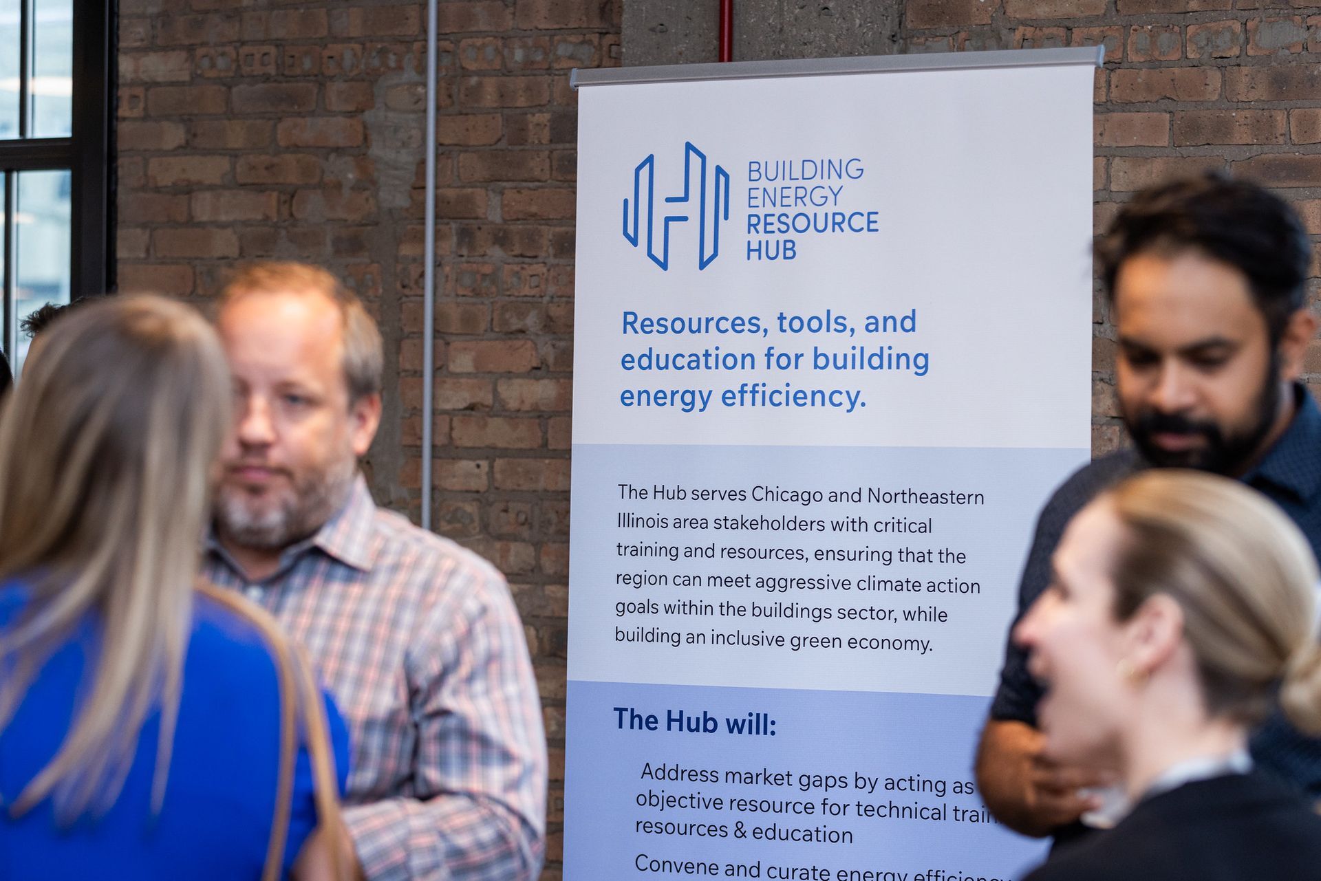 A group of people standing around a sign that says building efficiency hill