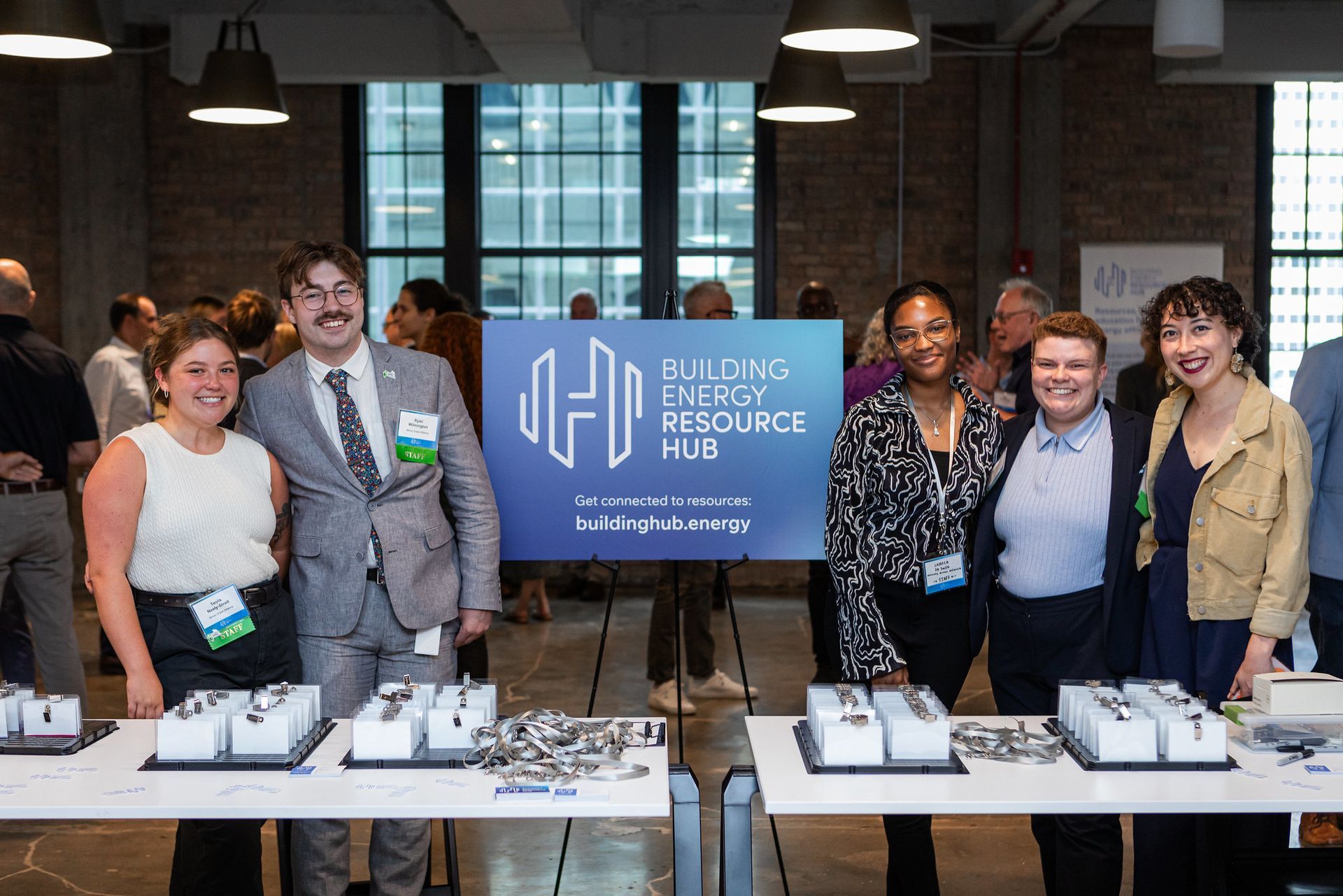 A group of people are posing for a picture in front of a sign that says building energy resource hub.