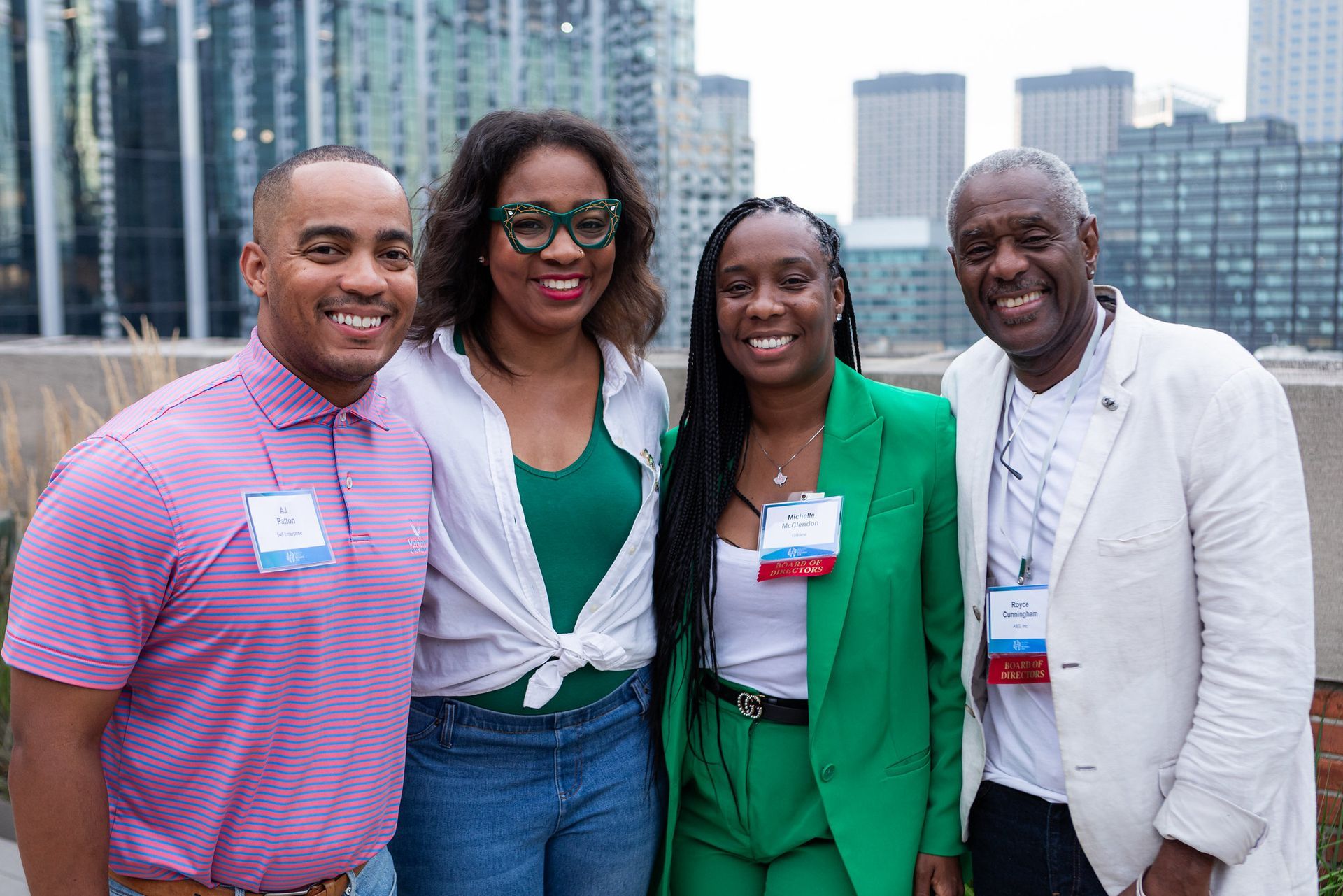 A group of people are posing for a picture together in front of a city skyline.