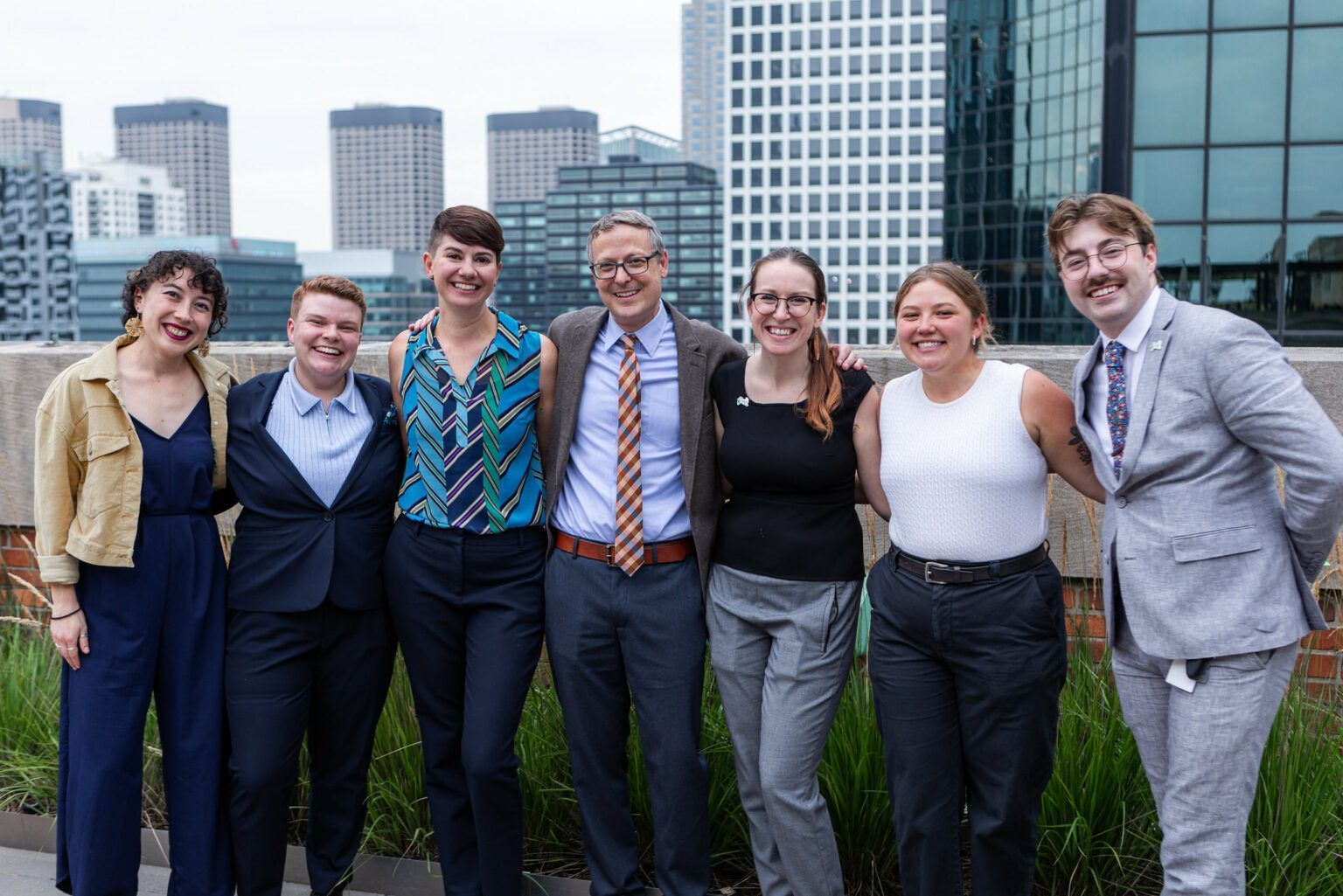 A group of people are posing for a picture in front of a city skyline.