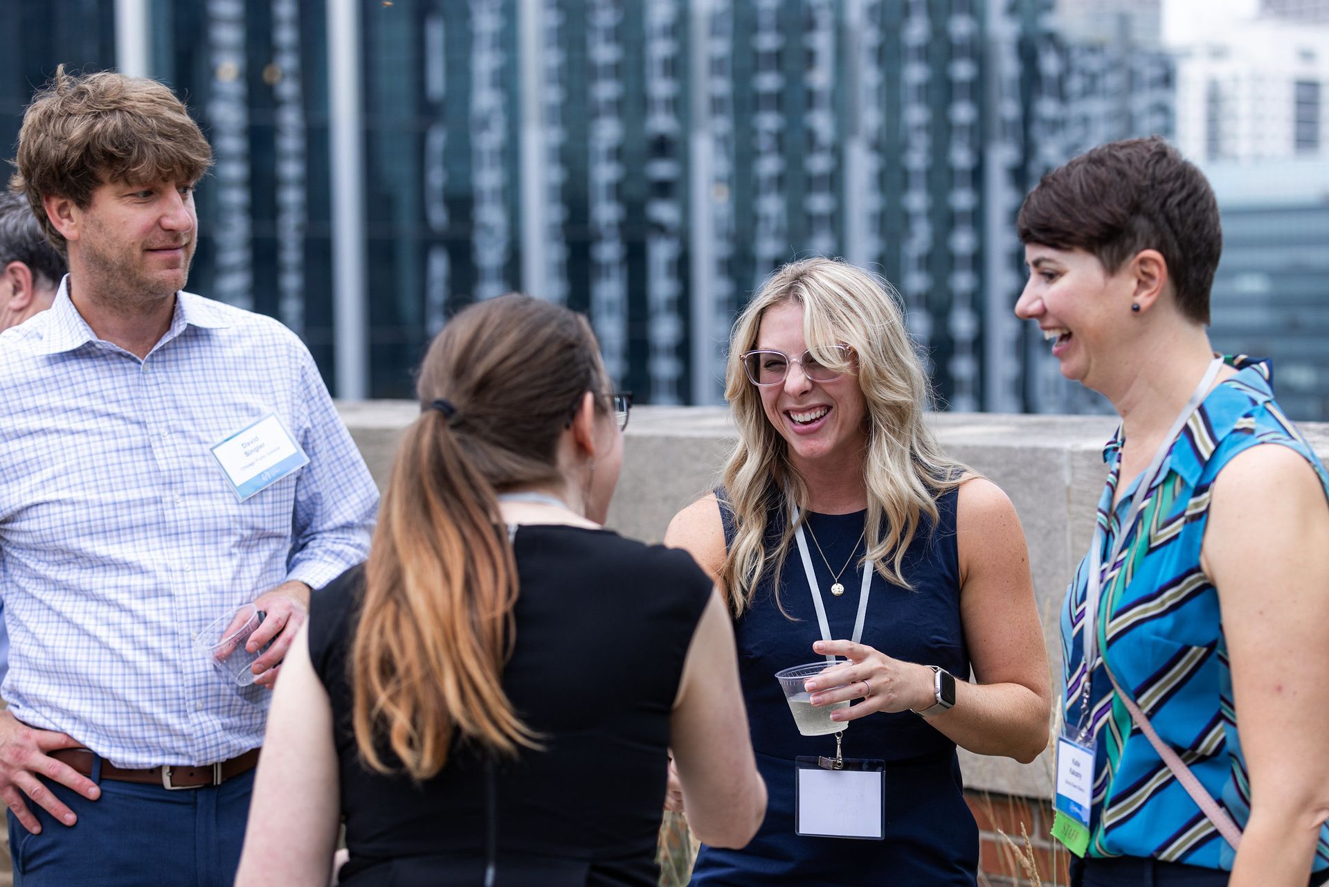 A group of people are standing around talking to each other.