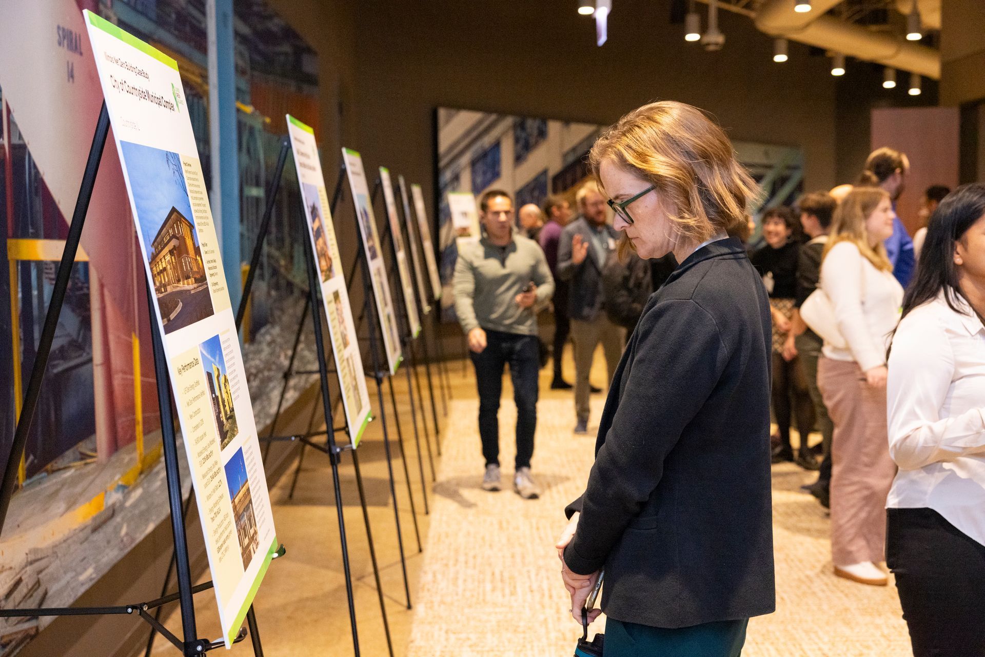 A woman is looking at a display of posters in a room.