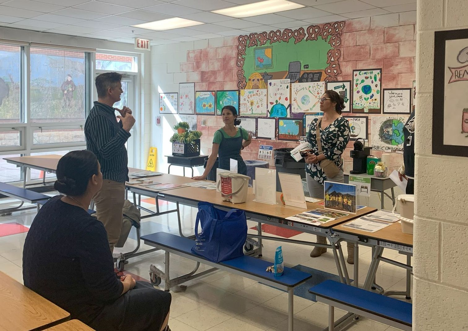 A group of people are standing around a table in a classroom.