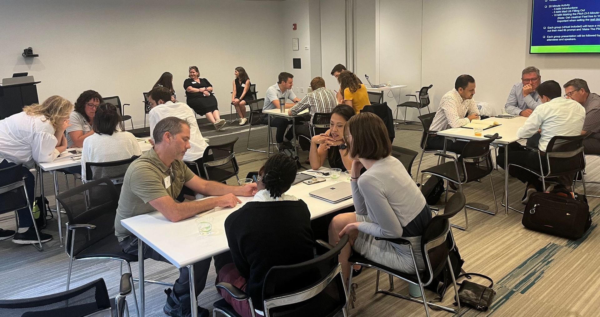 A group of people are sitting at tables in a room.