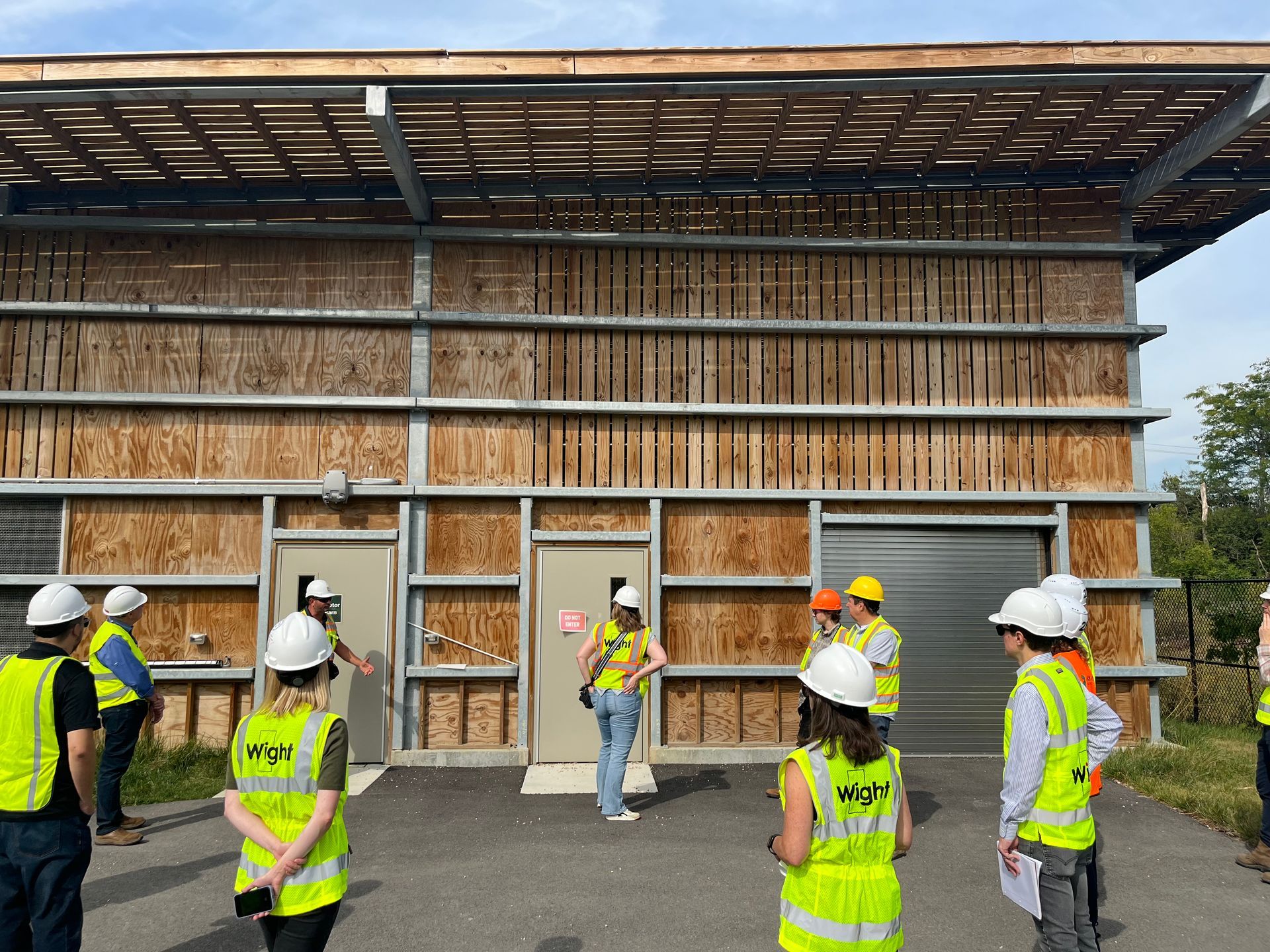 A group of construction workers are standing in front of a building.