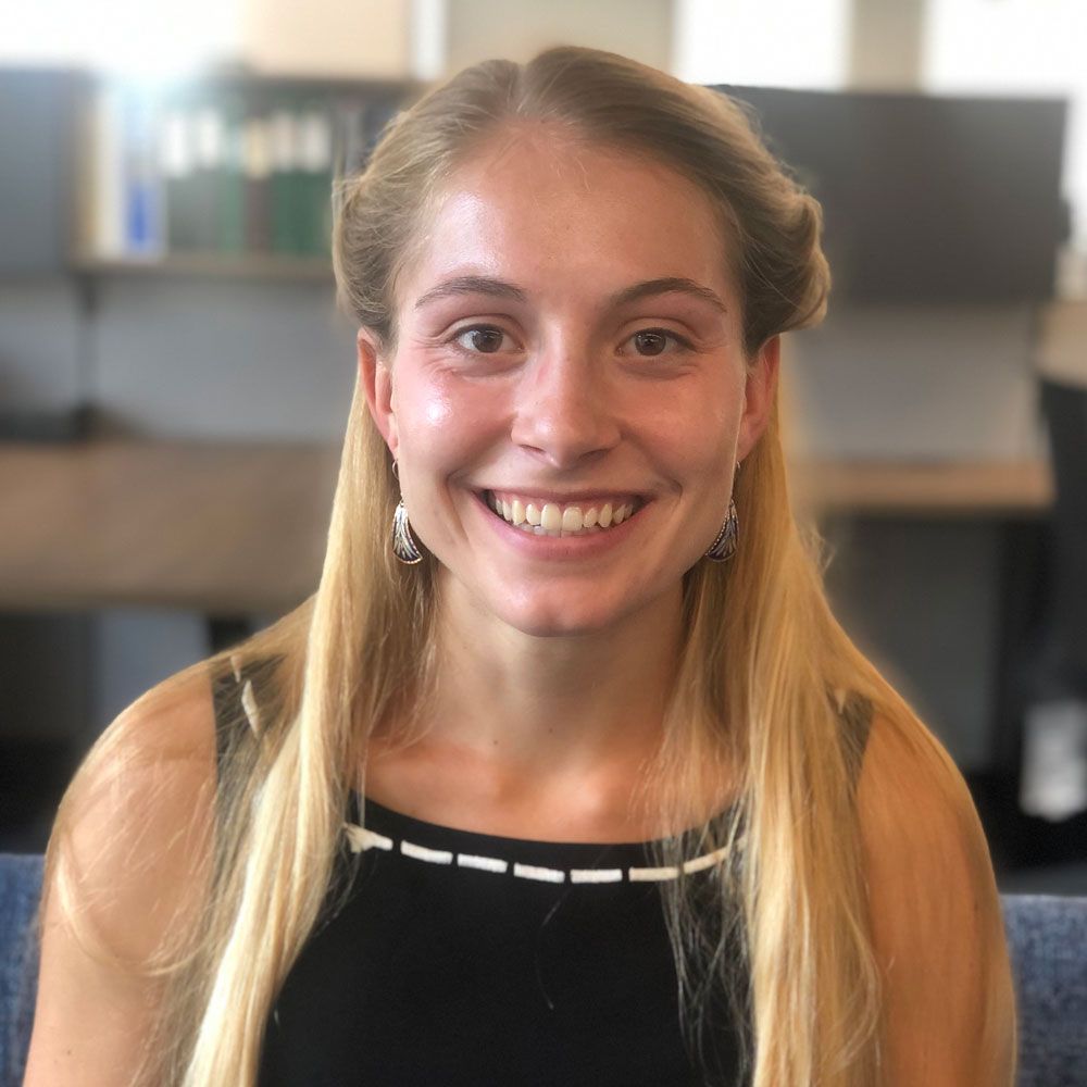 A woman with long blonde hair is smiling for the camera