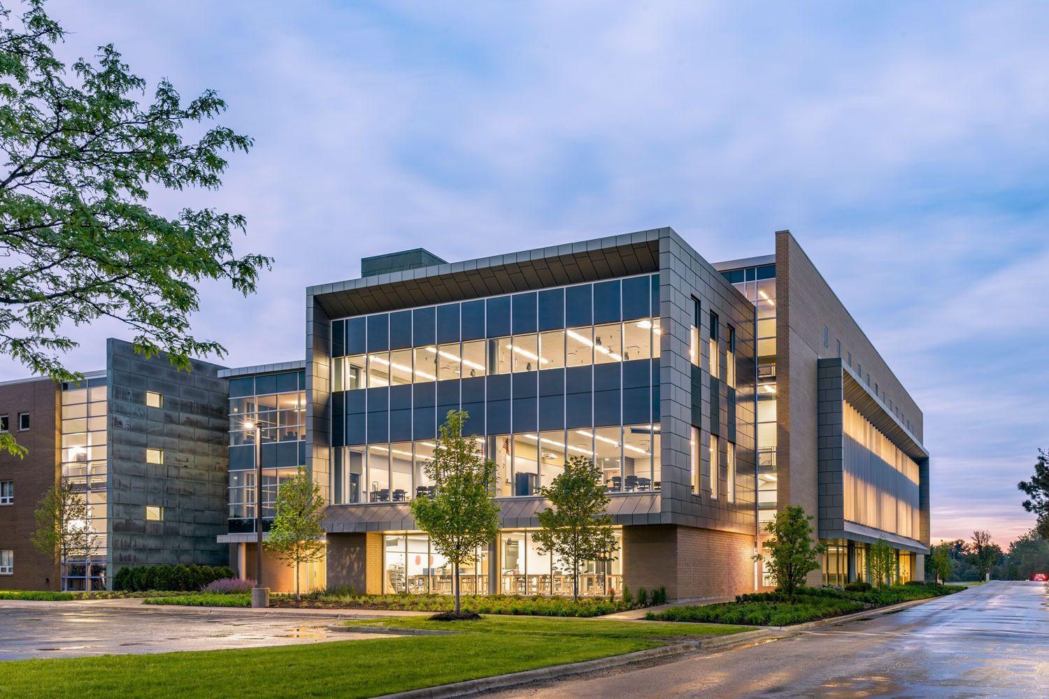 A large building with a lot of windows is lit up at night.