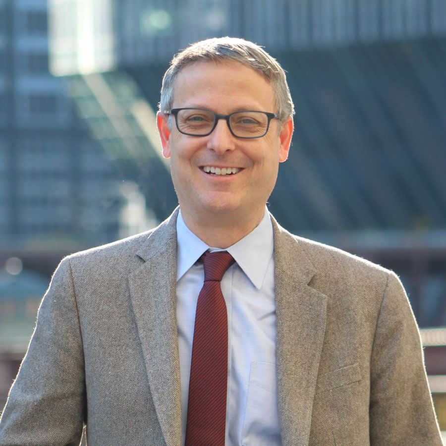 A man in a suit and tie is smiling for the camera