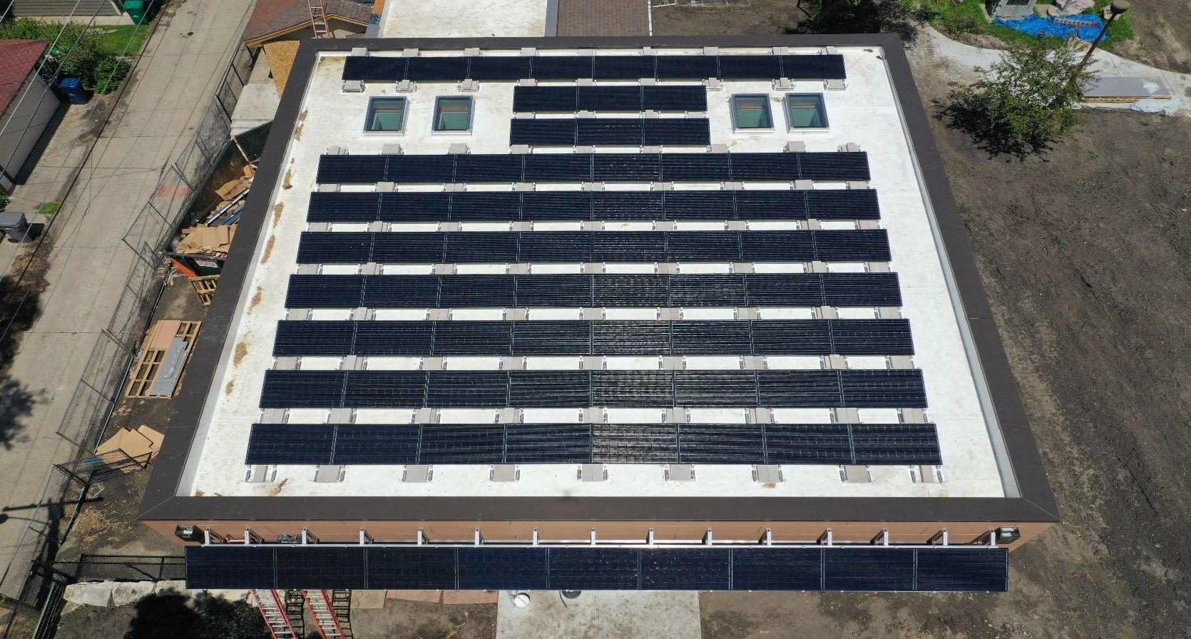 An aerial view of a building with solar panels on the roof.