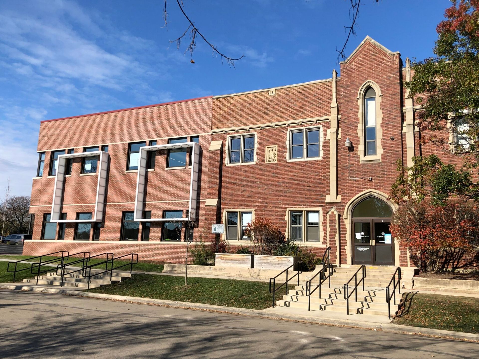 A large brick building with a lot of windows and stairs in front of it.