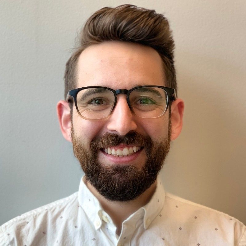 A man with a beard and glasses is smiling for the camera.