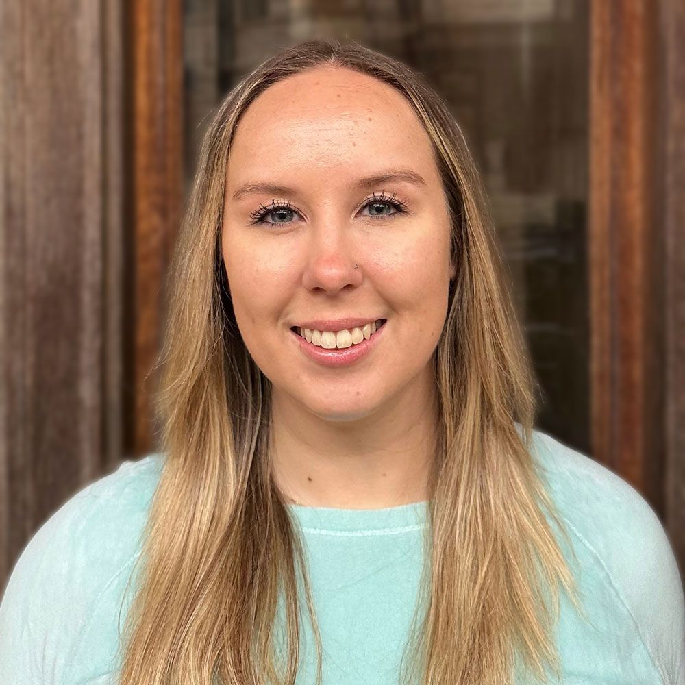 A woman with long blonde hair is smiling for the camera.