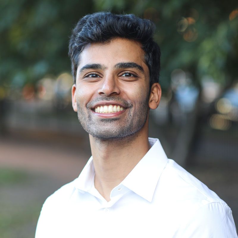 A man in a white shirt is smiling for the camera.