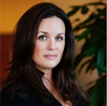 A woman with short hair is smiling for the camera