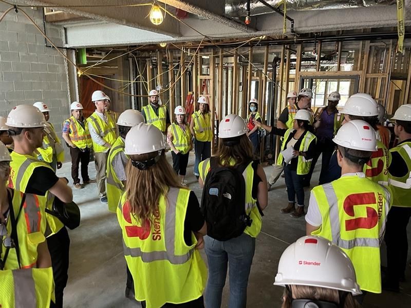 A group of construction workers are standing in a building under construction.
