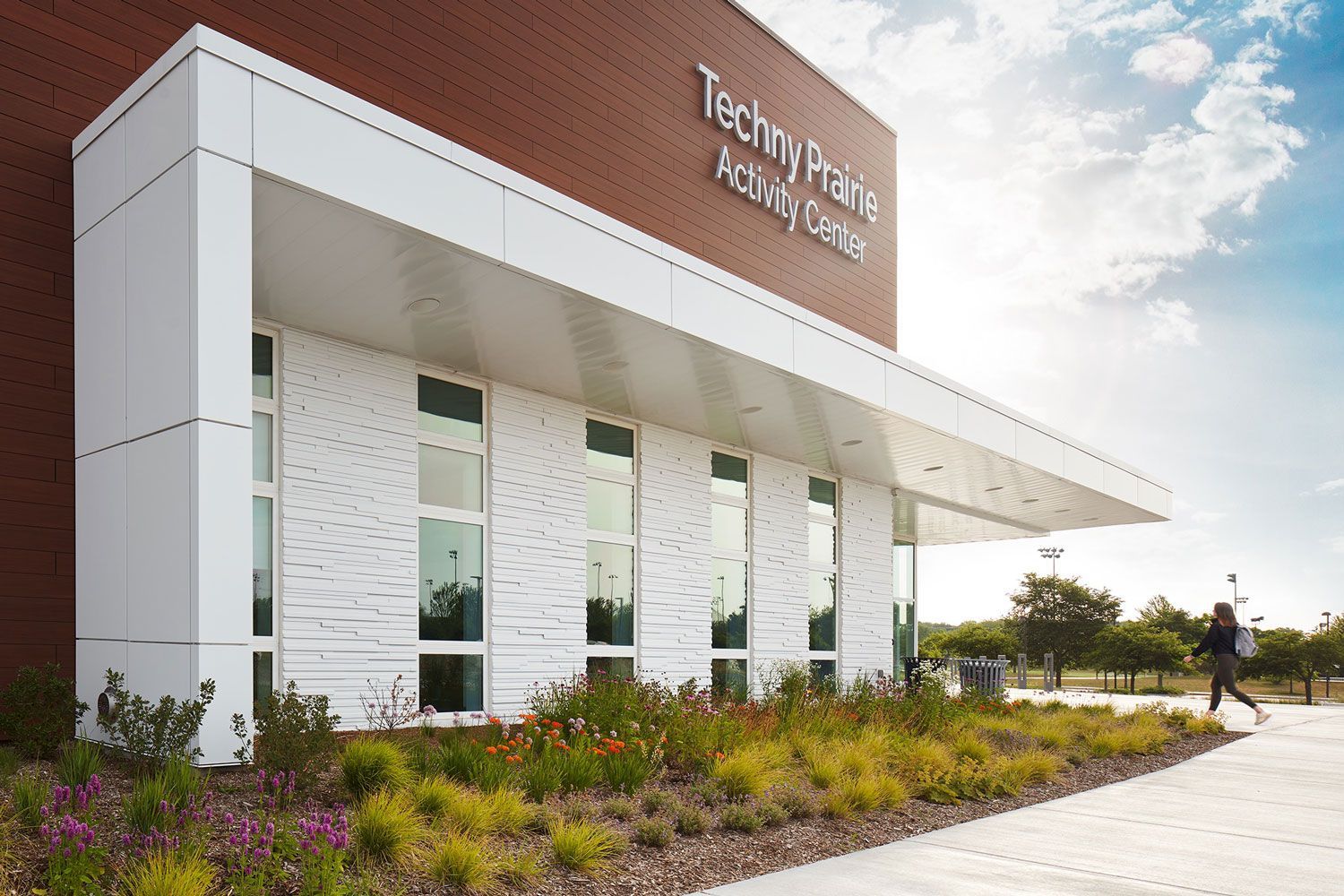 A person is walking in front of a building that says technifield activity center