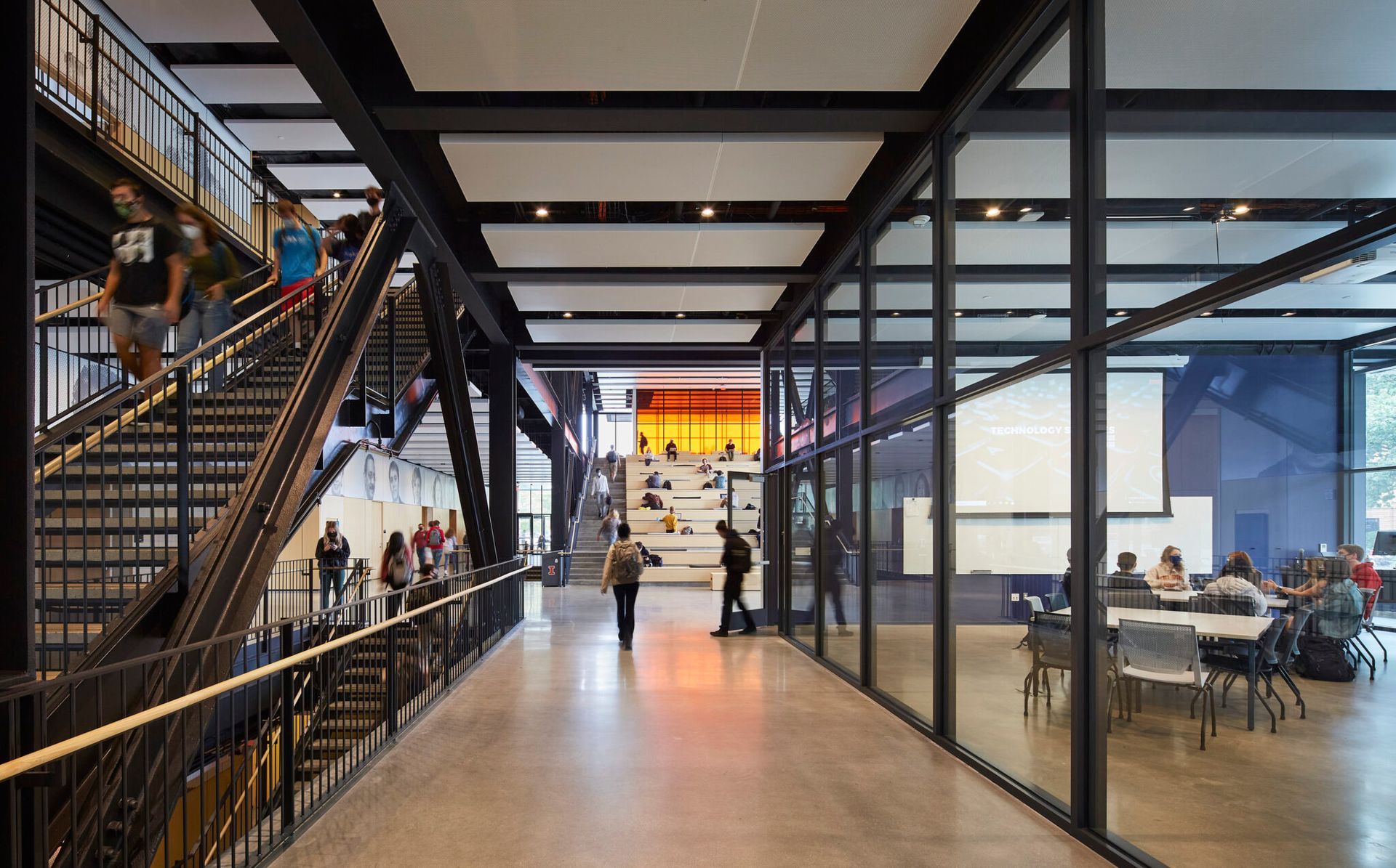 A group of people are walking down stairs in a building.