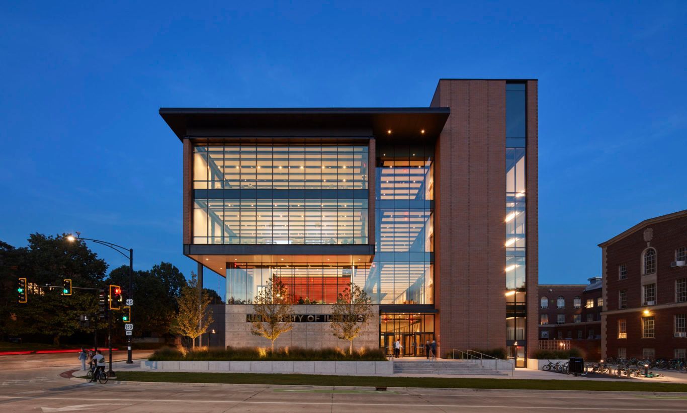 A large building with a lot of windows is lit up at night.