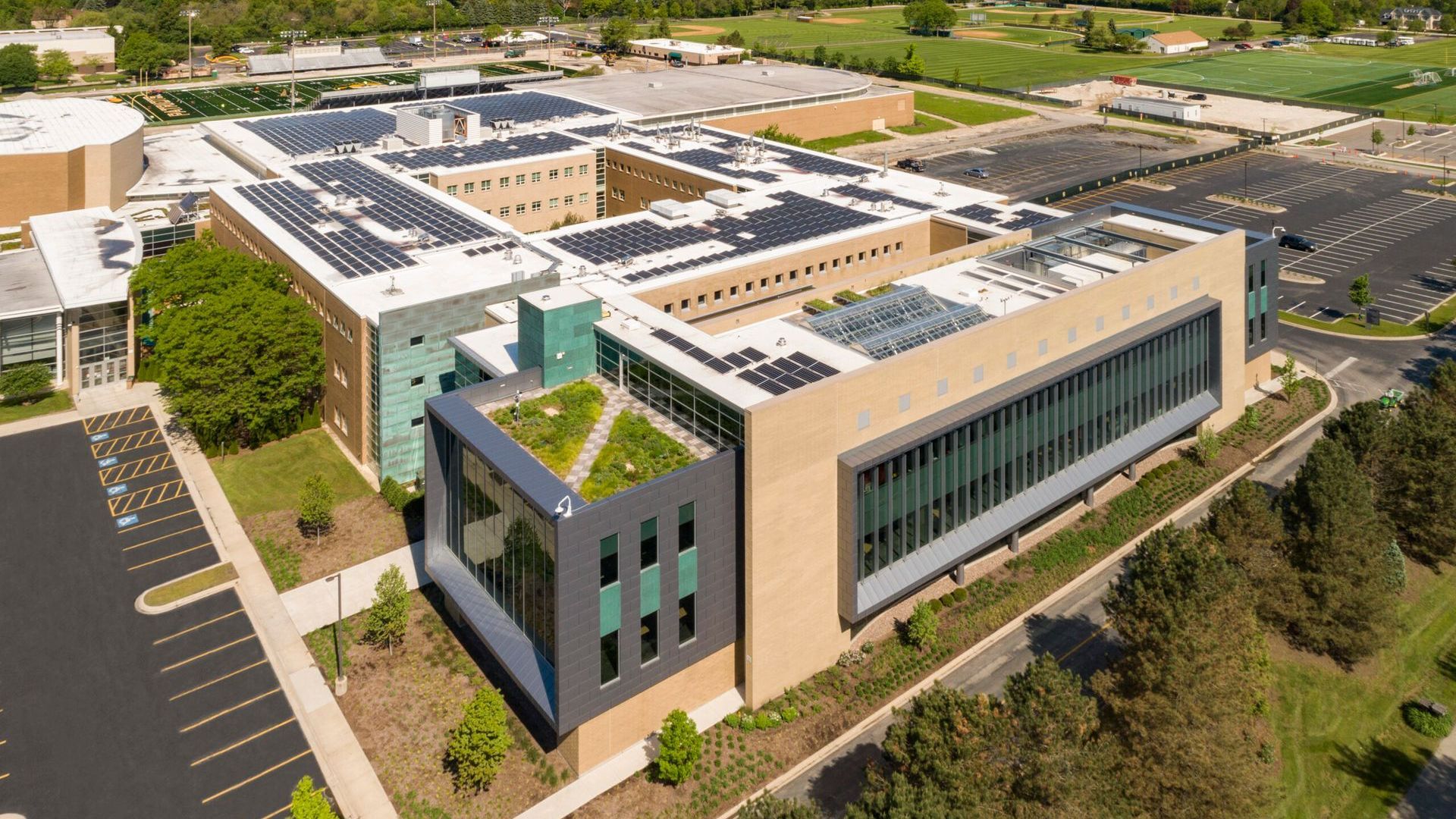 An aerial view of a large building with solar panels on the roof.