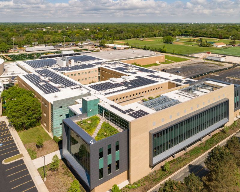 An aerial view of a large building with solar panels on the roof.