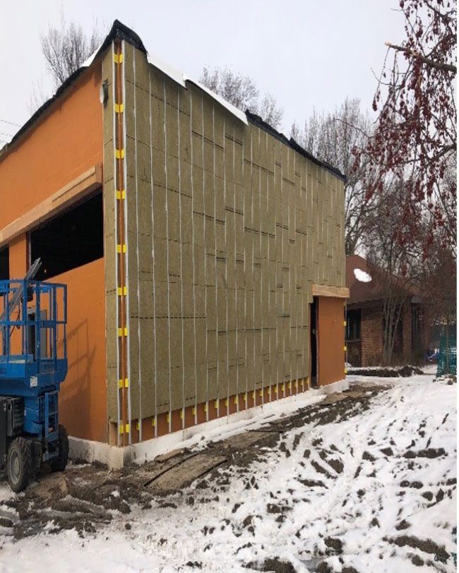 A building under construction with a blue lift in front of it